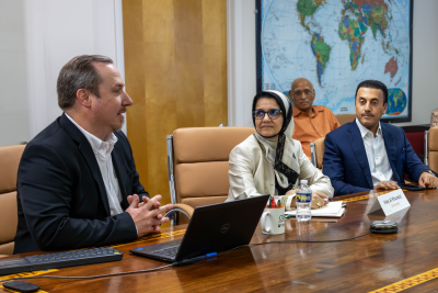 Three people sitting and talking around a conference table